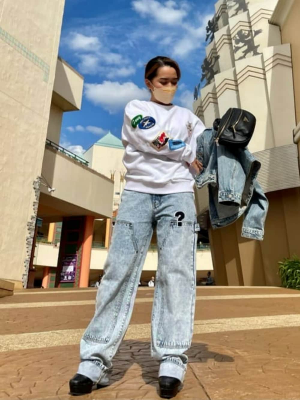 ブルー系のデニムパンツ、ブルー系のデニムジャケット、ホワイト系のスウェットを着用したレディースの秋コーディネートの1枚目の写真