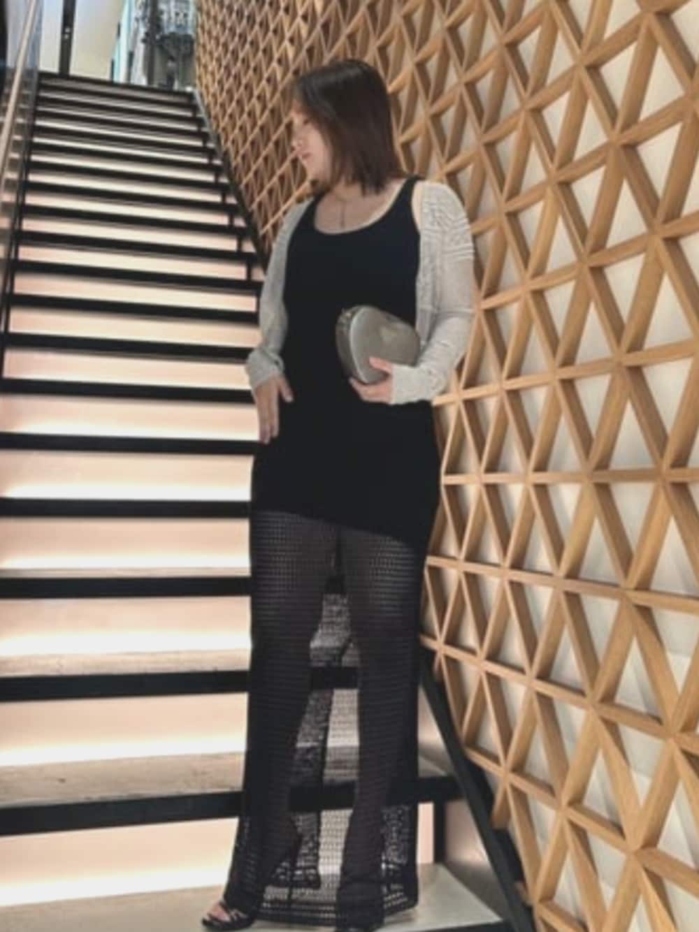 グレー系のショルダーバッグ、ブラック系のワンピース、ホワイト系のカーディガン/ボレロを着用したレディースの夏コーディネートの1枚目の写真