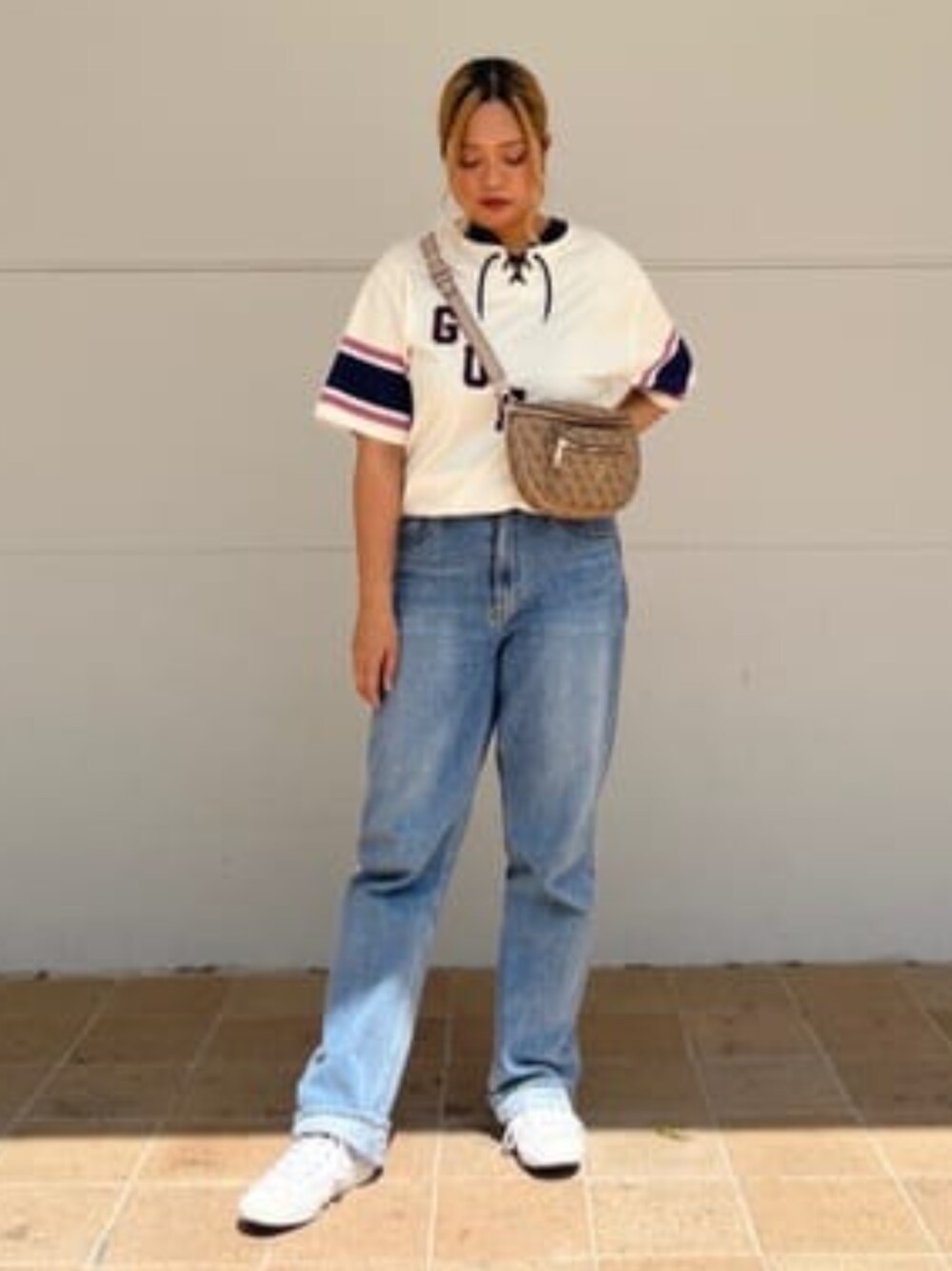 ブルー系のデニムパンツ、ベージュ系のボディバッグ/ウエストポーチ、ホワイト系のワンピースを着用したレディースの夏コーディネートの1枚目の写真