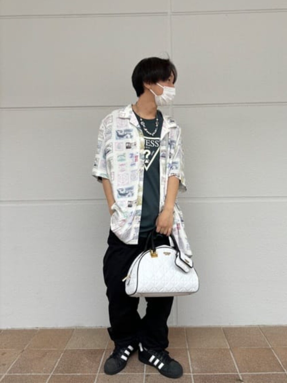 ホワイト系のハンドバッグ、ホワイト系のシャツ/ブラウス、ブラック系のTシャツ/カットソーを着用したメンズの春コーディネートの1枚目の写真