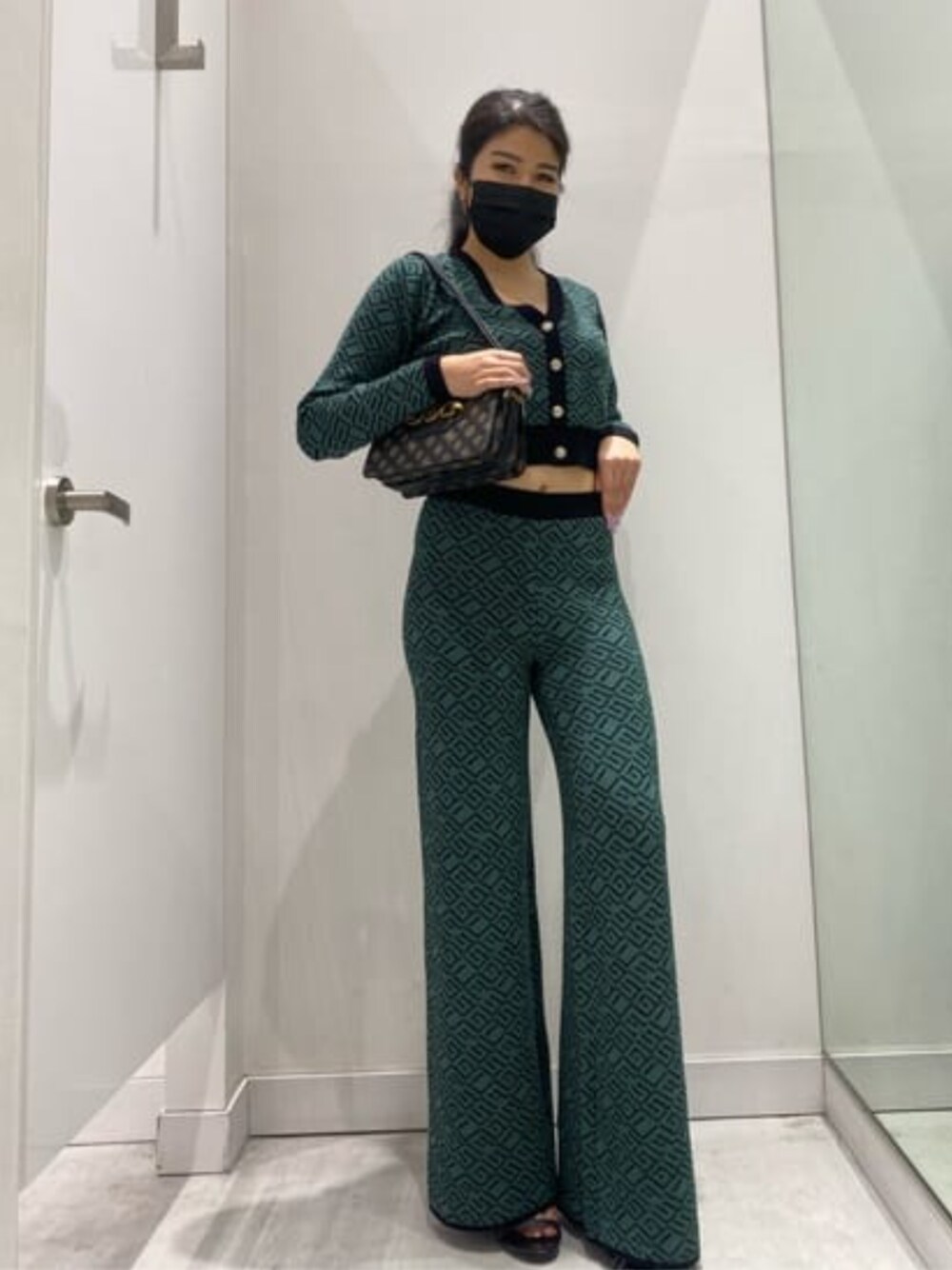 グリーン系のその他パンツ、グリーン系のカーディガン/ボレロ、レッド系のショルダーバッグを着用したレディースの冬コーディネートの1枚目の写真