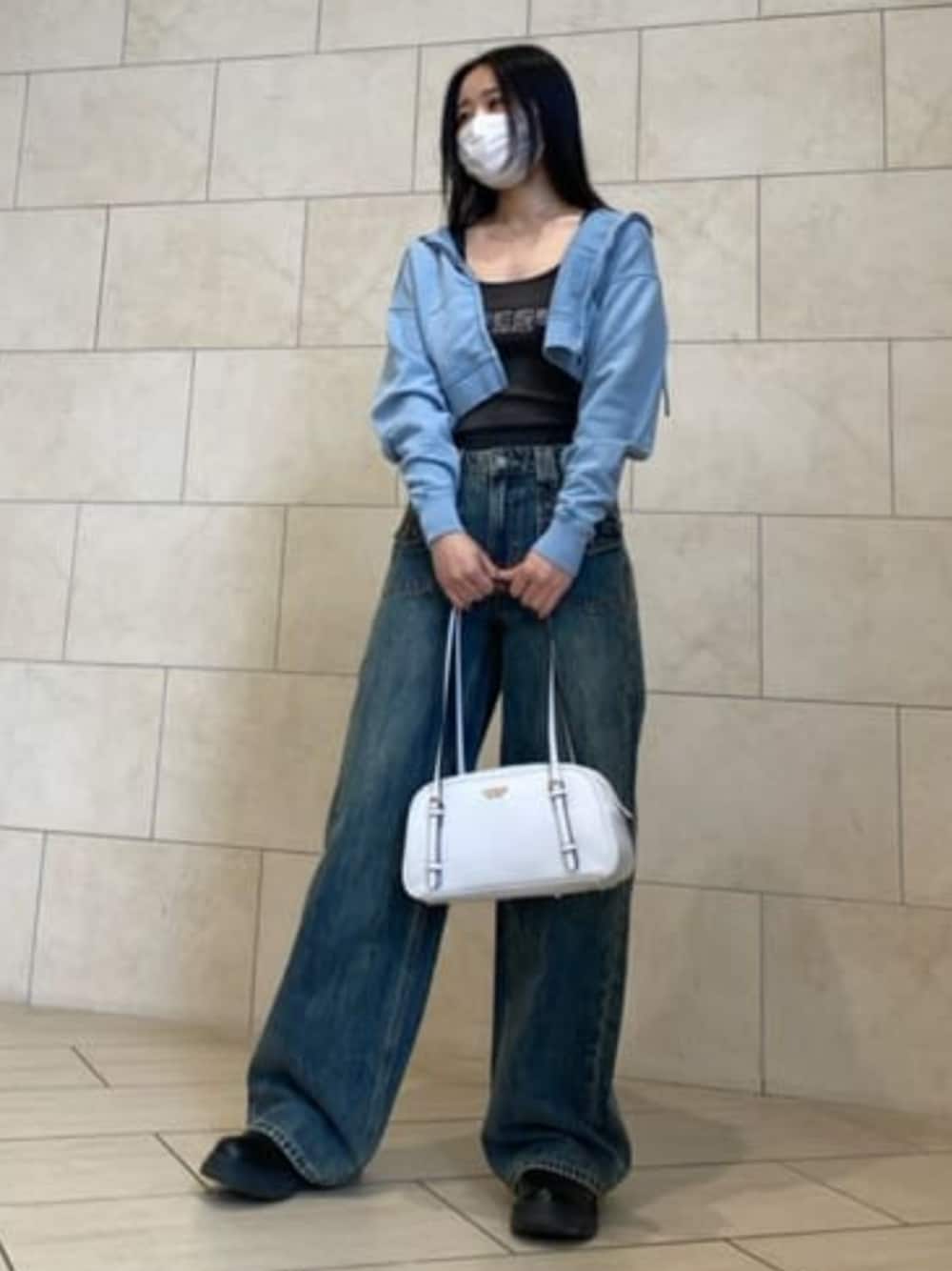 ブルー系のデニムパンツ、ホワイト系のショルダーバッグ、ブルー系のパーカーを着用したレディースの春コーディネートの1枚目の写真