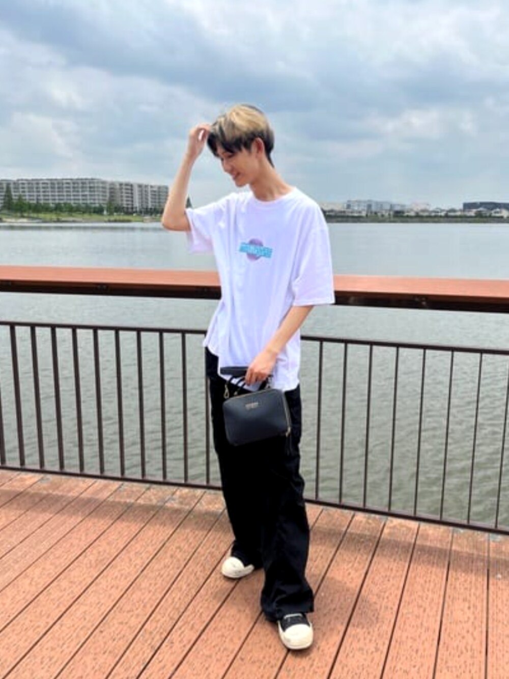 ブラック系のカーゴパンツ、ホワイト系のTシャツ/カットソーを着用したメンズの夏コーディネートの1枚目の写真