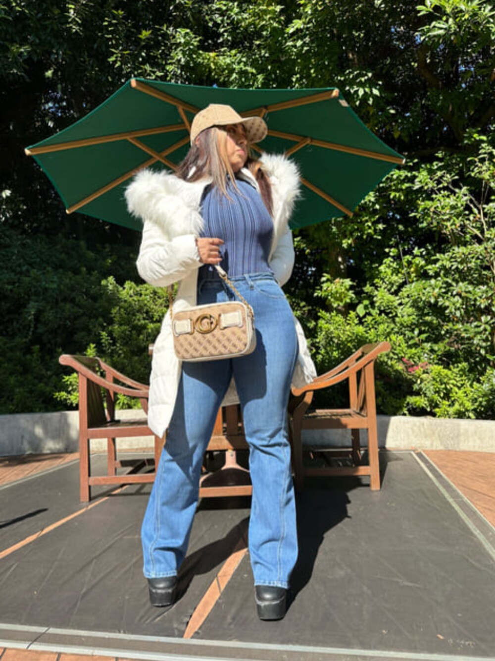 ブルー系のデニムパンツ、ホワイト系のショルダーバッグ、ホワイト系のその他アウターを着用したレディースの冬コーディネートの1枚目の写真