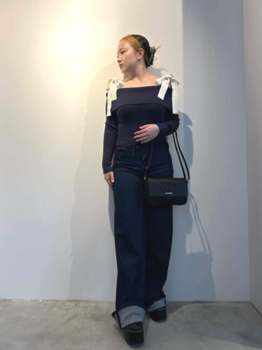 ブラック系のショルダーバッグ、ブルー系のデニムパンツ、ブルー系のTシャツ/カットソーを着用したレディースの春コーディネートの1枚目の写真