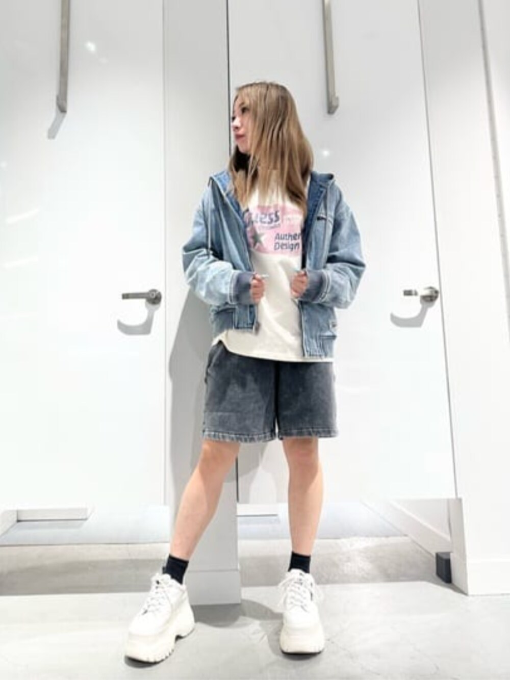 ブラック系のデニムパンツ、ホワイト系のTシャツ/カットソーを着用したレディースの春コーディネートの1枚目の写真