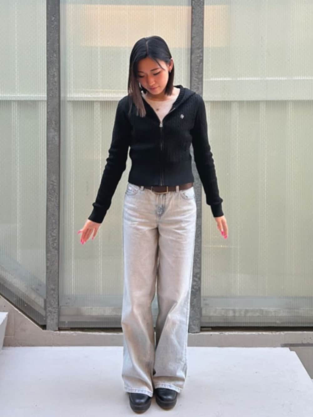 ブラック系のカーディガン/ボレロ、ブルー系のデニムパンツを着用したレディースの冬コーディネートの1枚目の写真