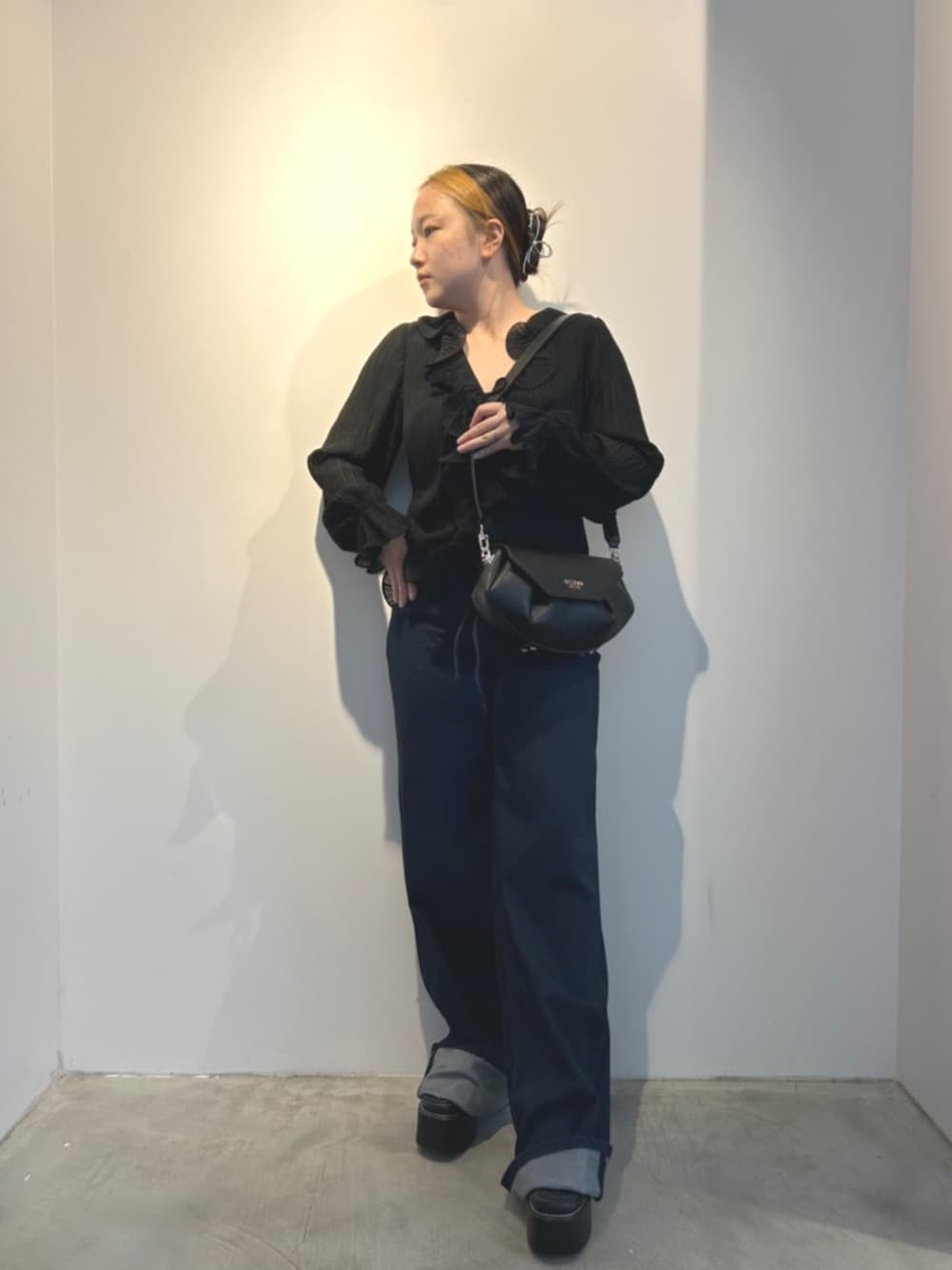 ブルー系のデニムパンツ、ブラック系のショルダーバッグ、ブラック系のシャツ/ブラウスを着用したレディースの冬コーディネートの1枚目の写真