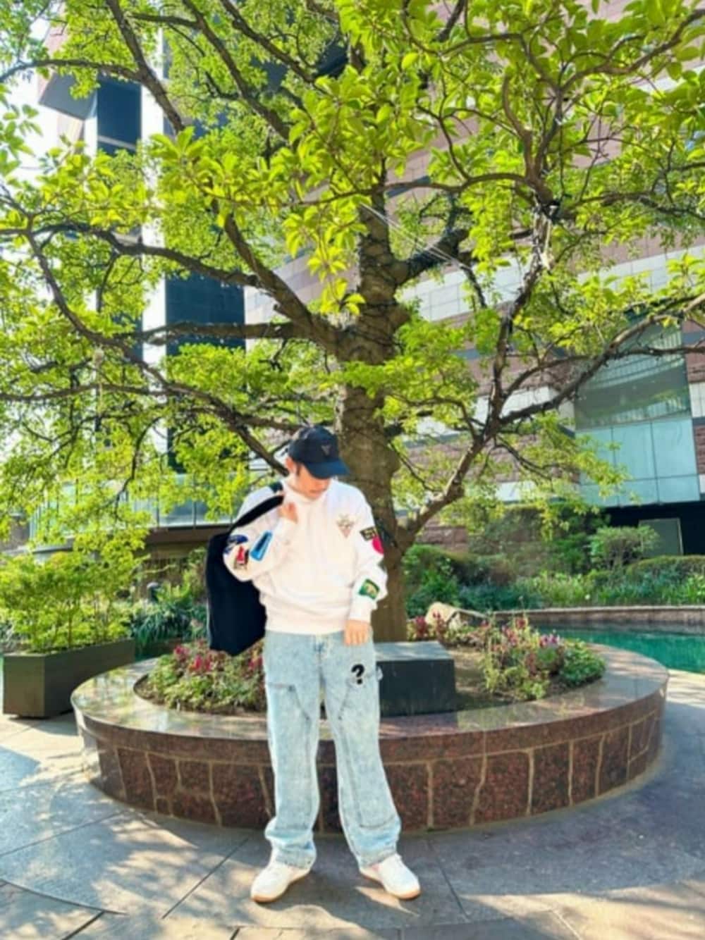 ホワイト系のスウェット、ブラック系のトートバッグ、ブルー系のデニムパンツを着用したメンズの秋コーディネートの1枚目の写真