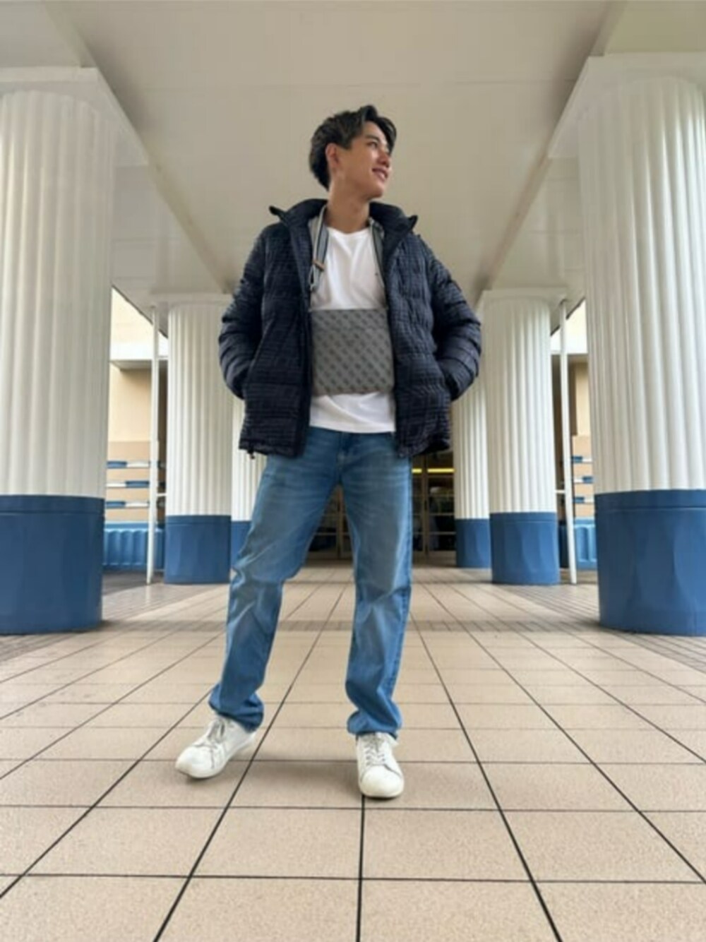 グレー系のショルダーバッグ、ブラック系のブルゾン、ホワイト系のTシャツ/カットソーを着用したメンズの秋コーディネートの1枚目の写真