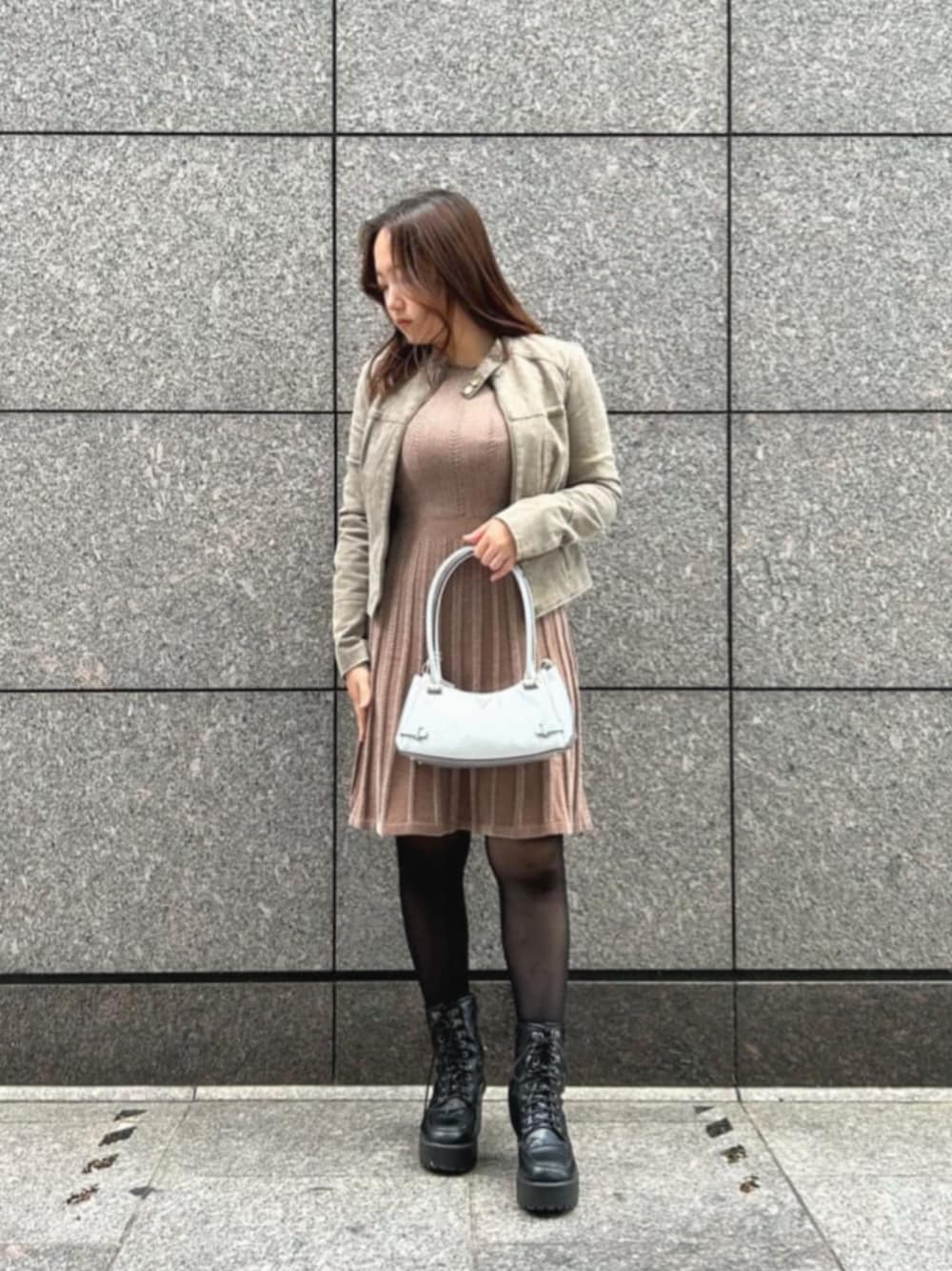 ベージュ系のノーカラージャケット、ベージュ系のワンピース、シルバー系のショルダーバッグを着用したレディースの秋コーディネートの1枚目の写真