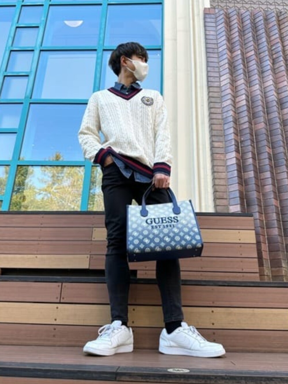 ホワイト系のニット/セーター、ブラック系のデニムパンツを着用したメンズの冬コーディネートの1枚目の写真