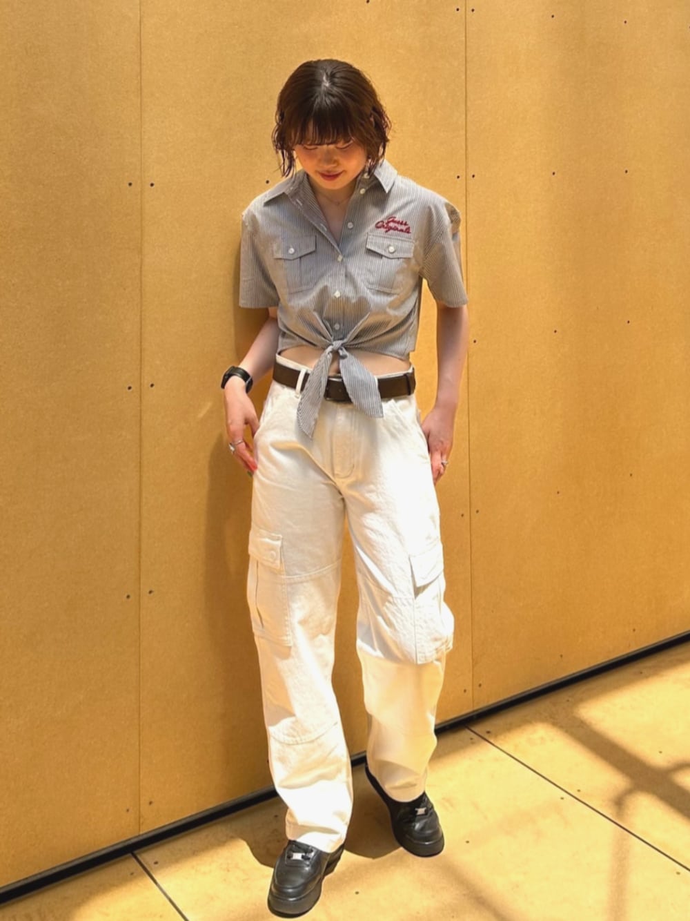 グレー系のシャツ/ブラウス、ホワイト系のカーゴパンツを着用したレディースの夏コーディネートの1枚目の写真