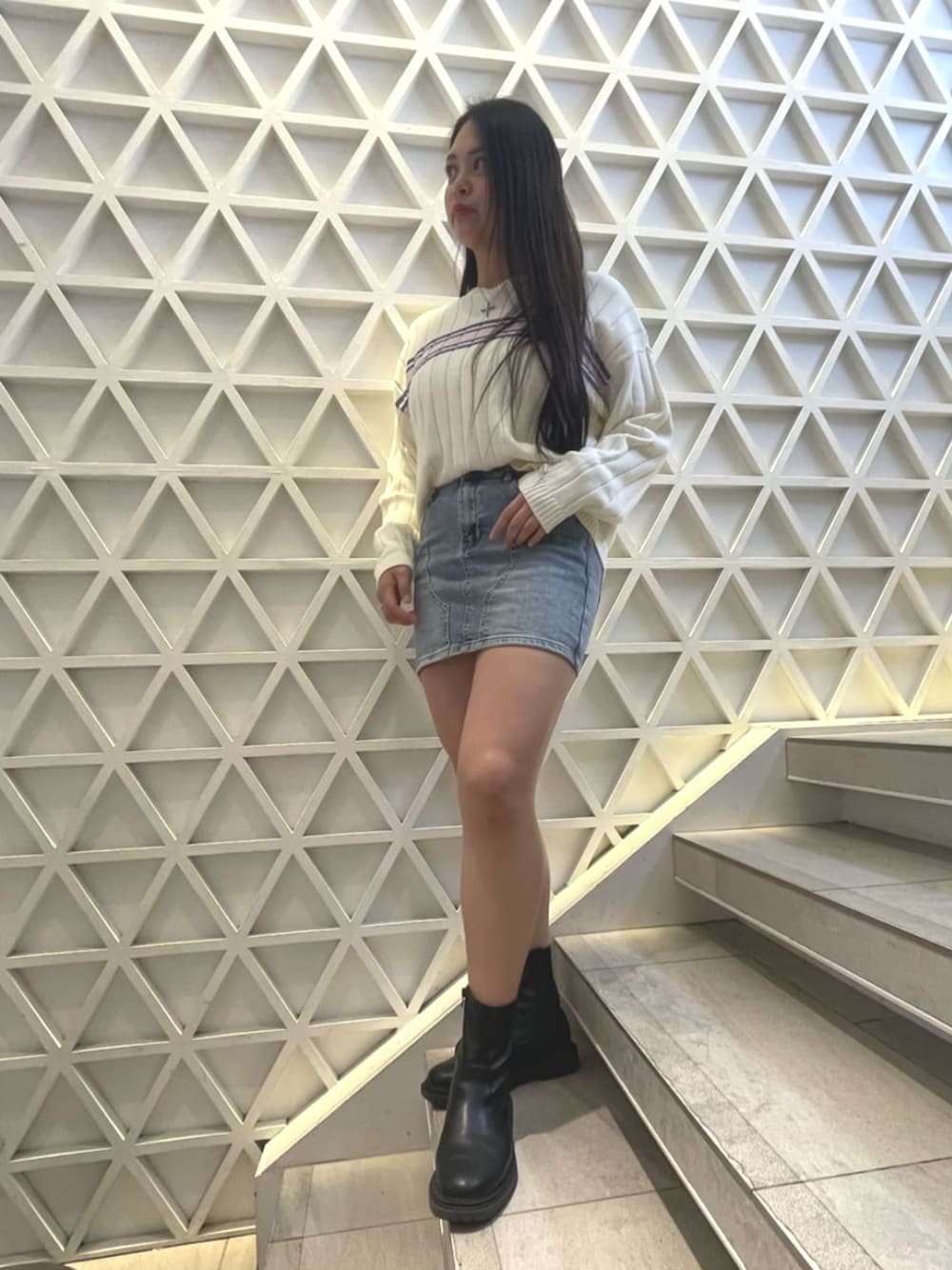 ホワイト系のニット/セーター、ブルー系のデニムスカートを着用したレディースの春コーディネートの1枚目の写真