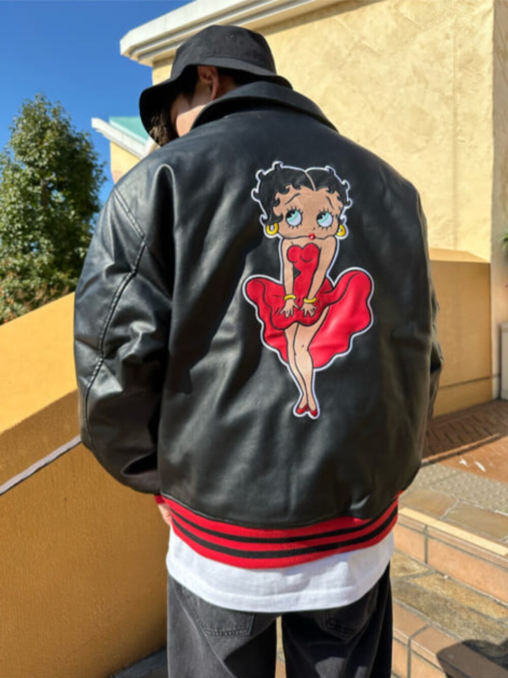 ブラック系のデニムパンツ、ブラック系のブルゾン、ホワイト系のTシャツ/カットソーを着用したメンズの秋コーディネートの1枚目の写真