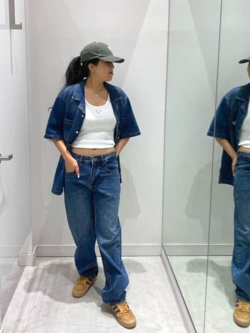 ブルー系のデニムパンツ、ブルー系のシャツ/ブラウス、グリーン系のキャップを着用したレディースの春コーディネートの1枚目の写真