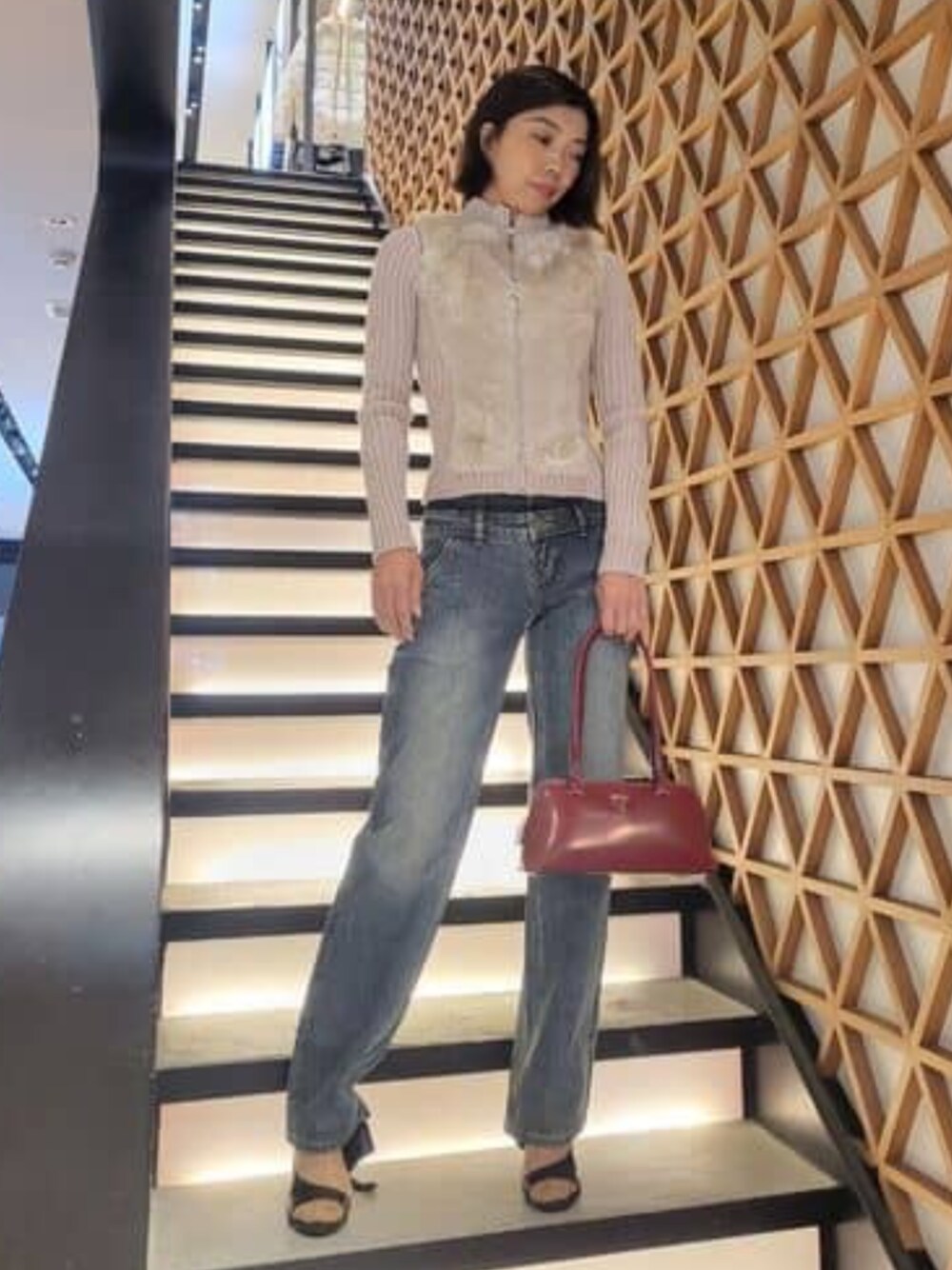 ブルー系のデニムパンツ、レッド系のショルダーバッグを着用したレディースの春コーディネートの1枚目の写真