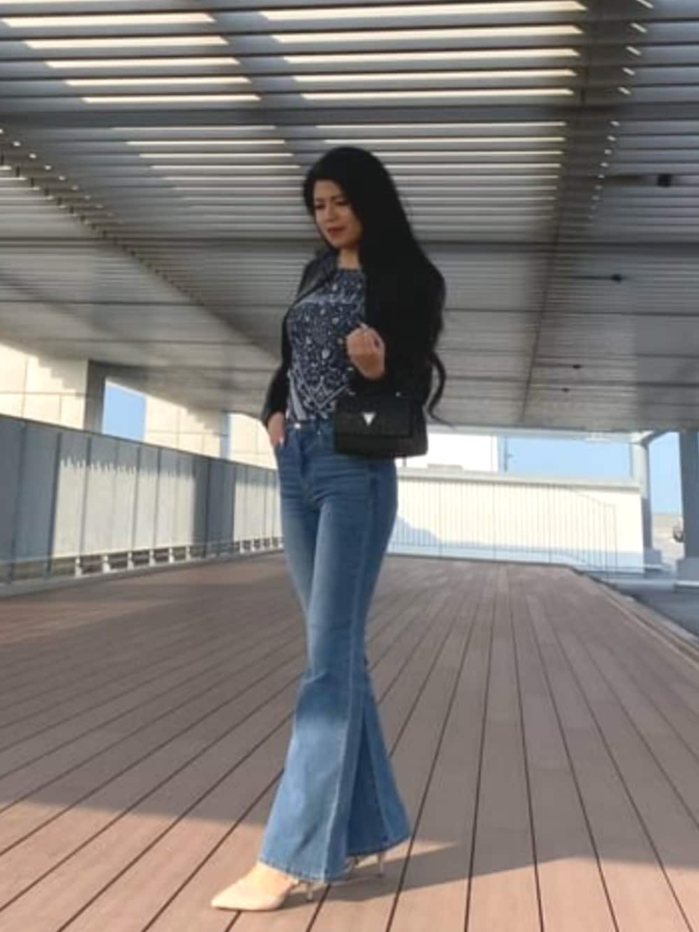 ブルー系のTシャツ/カットソー、ブラック系のライダースジャケット、ブラック系のハンドバッグを着用したレディースの春コーディネートの1枚目の写真