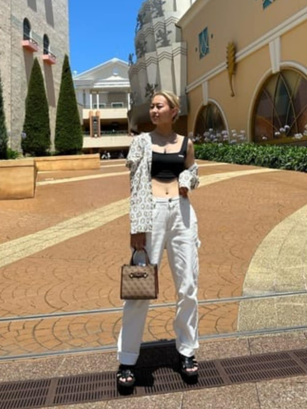 ベージュ系のシャツ/ブラウス、ブラック系のその他トップス、ホワイト系のデニムパンツを着用したレディースの夏コーディネートの1枚目の写真