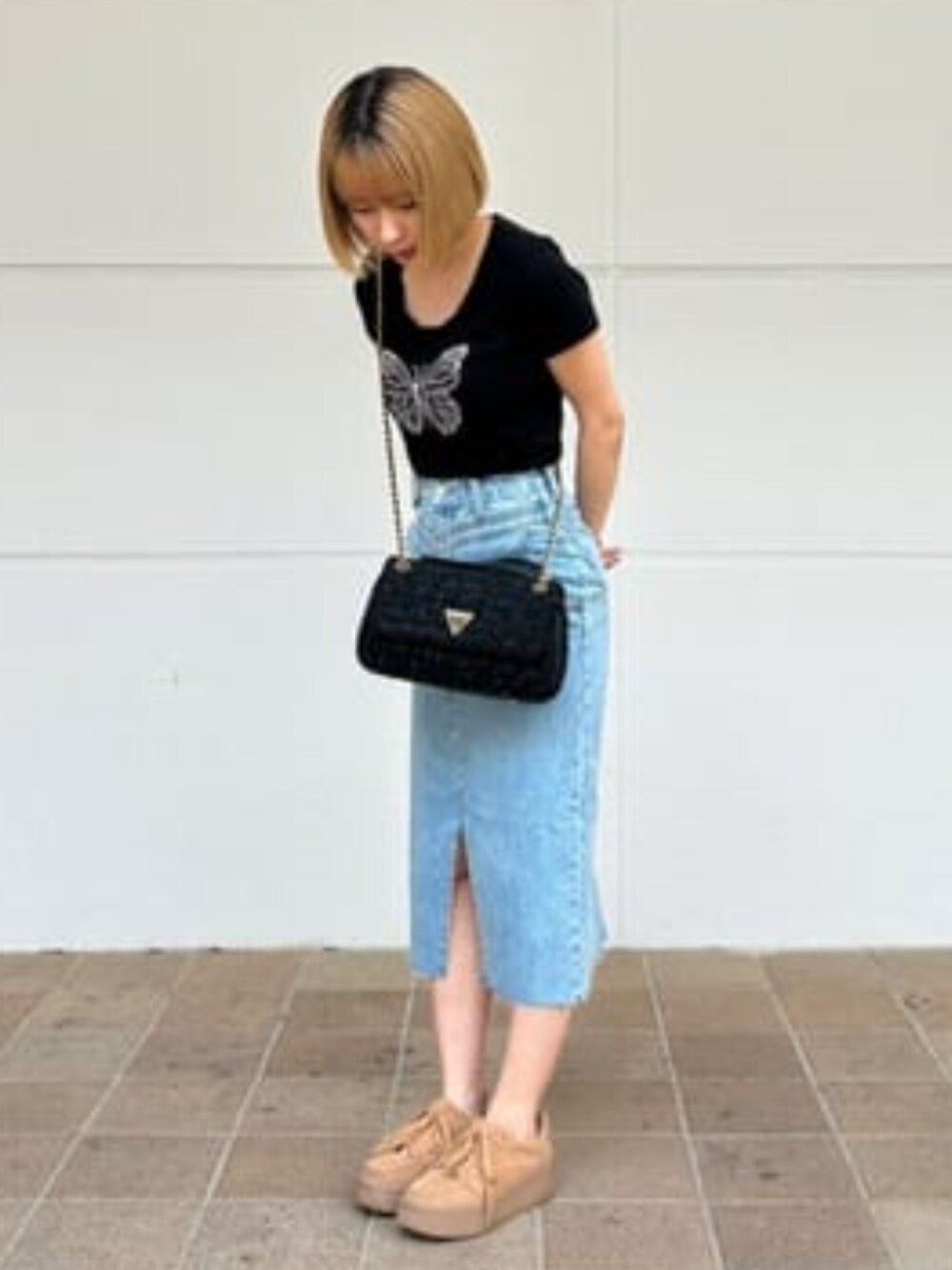 ブルー系のデニムスカートを着用したレディースの夏コーディネートの1枚目の写真