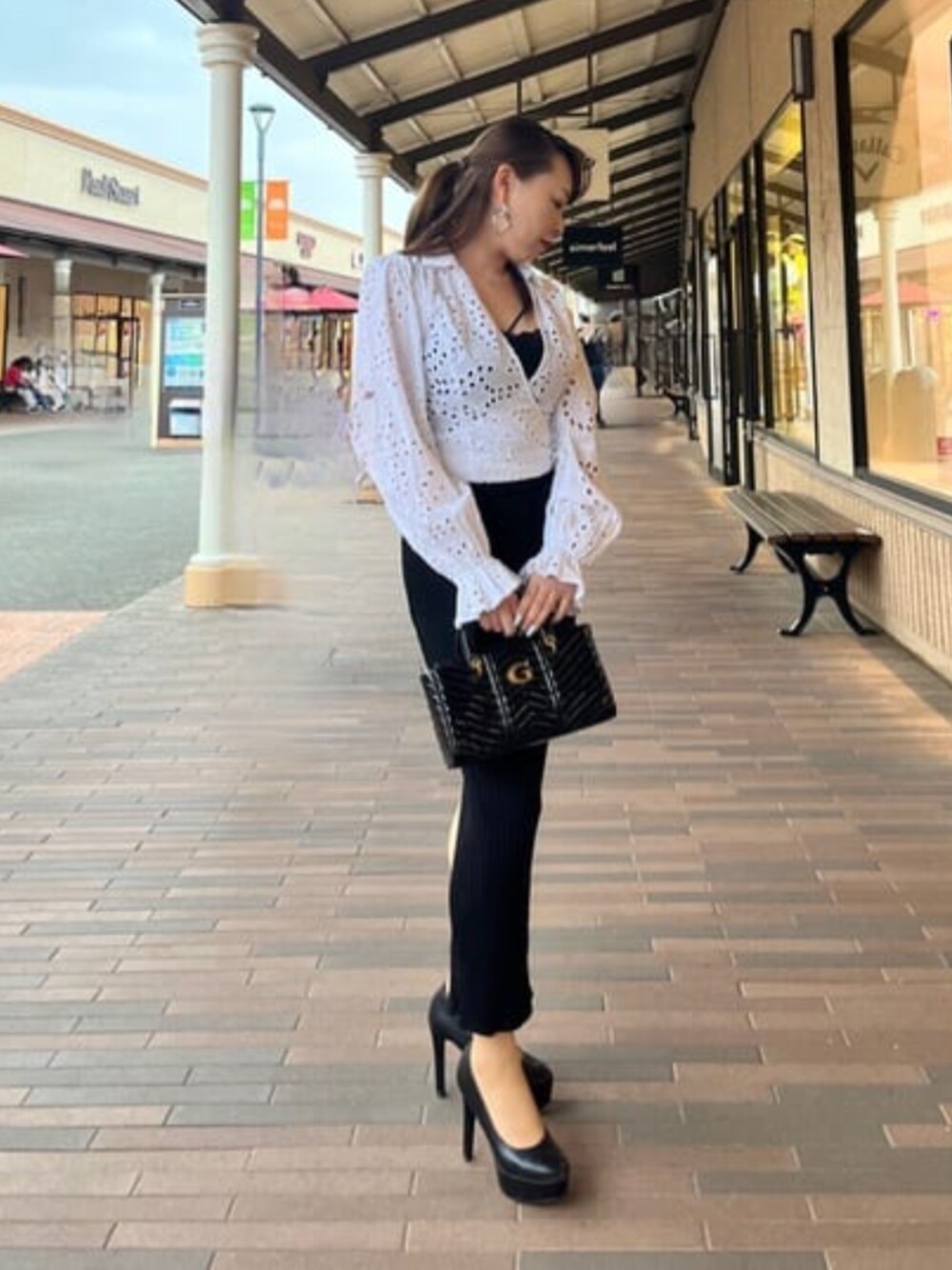 ブラック系のハンドバッグを着用したレディースの春コーディネートの1枚目の写真