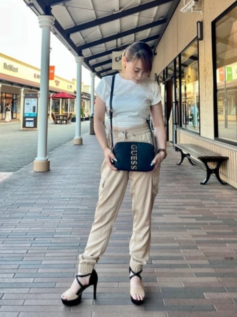 ブラック系のショルダーバッグ、ホワイト系のその他トップスを着用したレディースの夏コーディネートの1枚目の写真