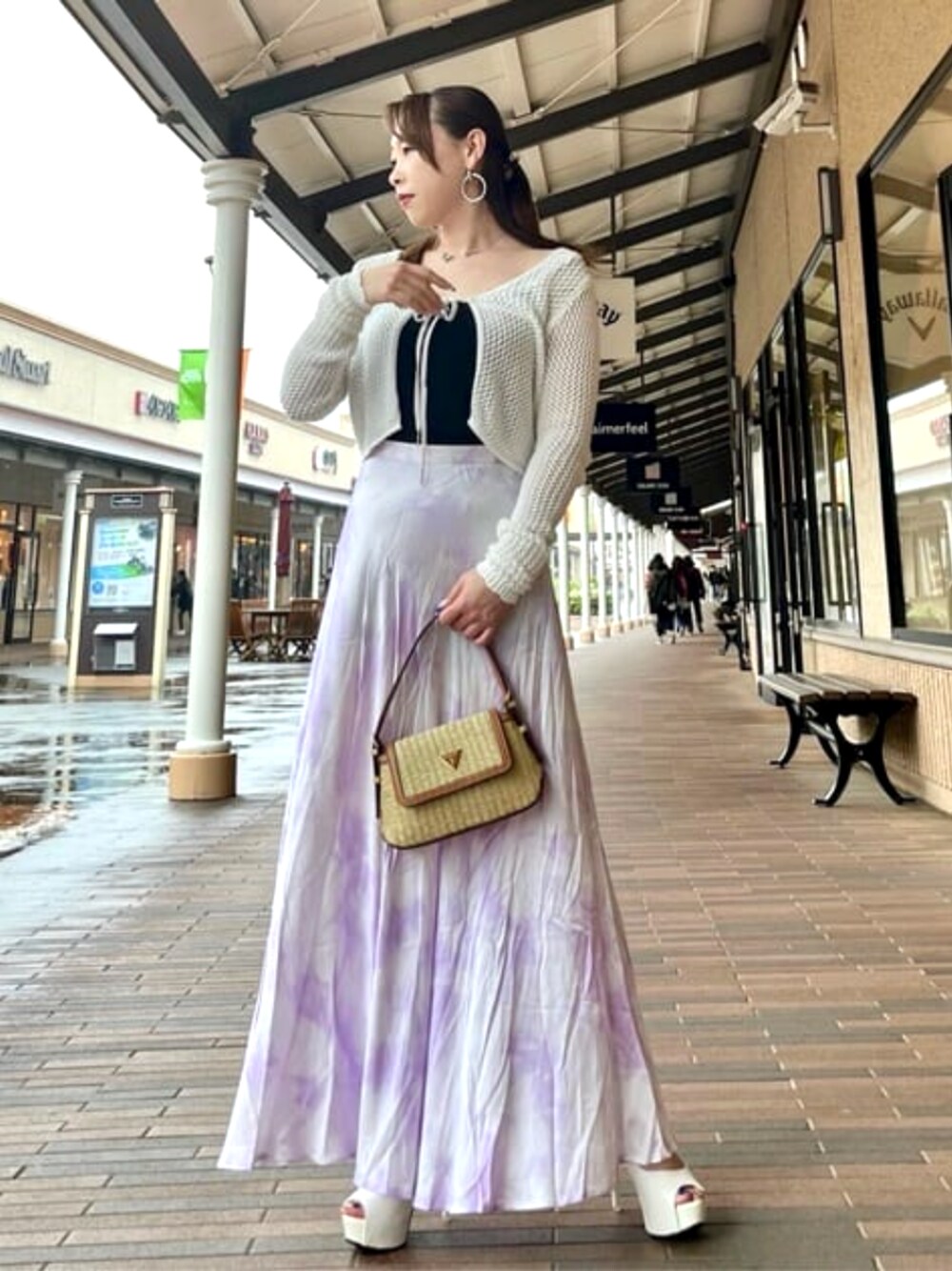 イエロー系のショルダーバッグ、ベージュ系のニット/セーター、パープル系のスカートを着用したレディースの春コーディネートの1枚目の写真