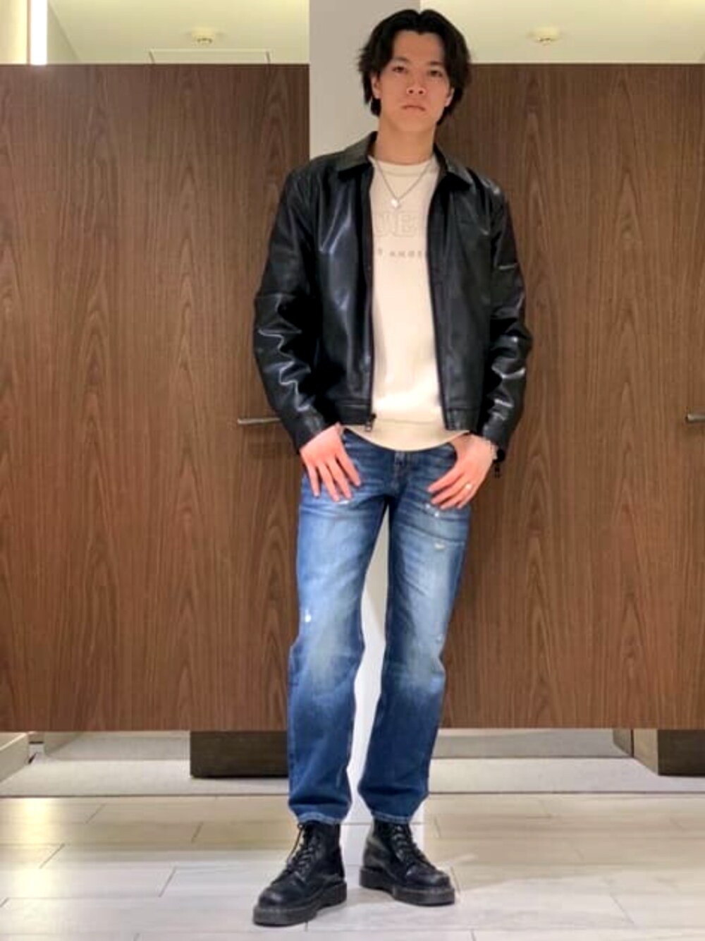 ブラック系のブルゾン、ホワイト系のスウェット、ブルー系のデニムパンツを着用したメンズの春コーディネートの1枚目の写真