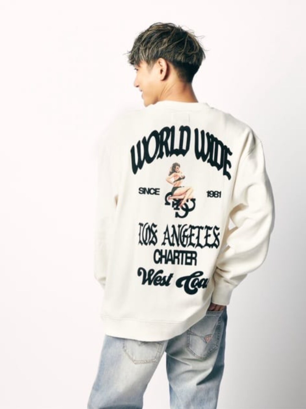 ブルー系のデニムパンツ、ホワイト系のスウェットを着用したメンズの春コーディネートの1枚目の写真