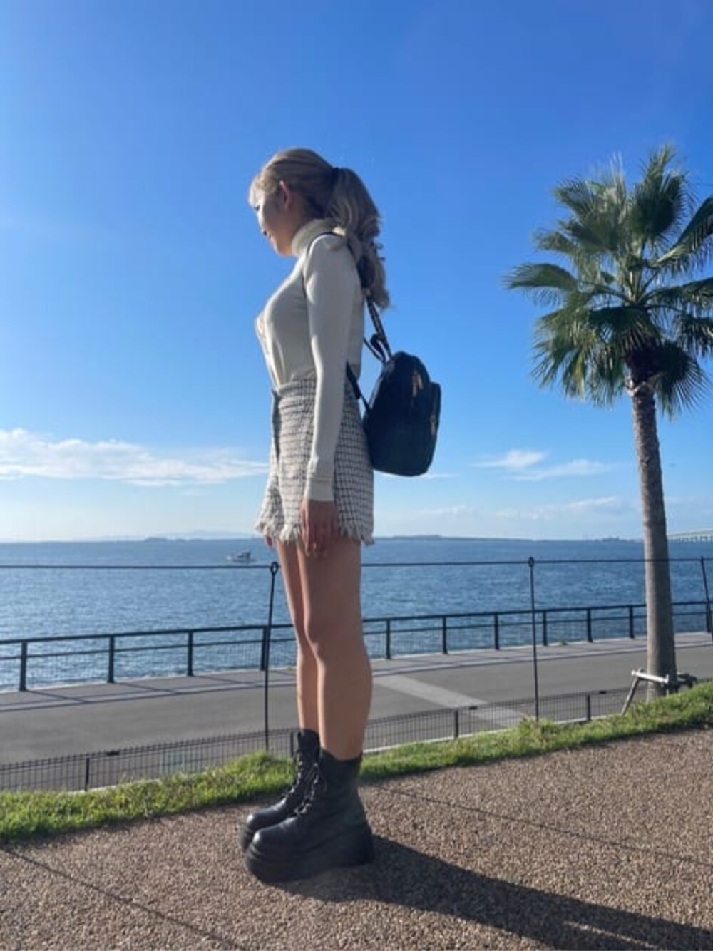 ブラック系のその他パンツ、ベージュ系のニット/セーター、ブラック系のバックパック/リュックを着用したレディースの冬コーディネートの1枚目の写真