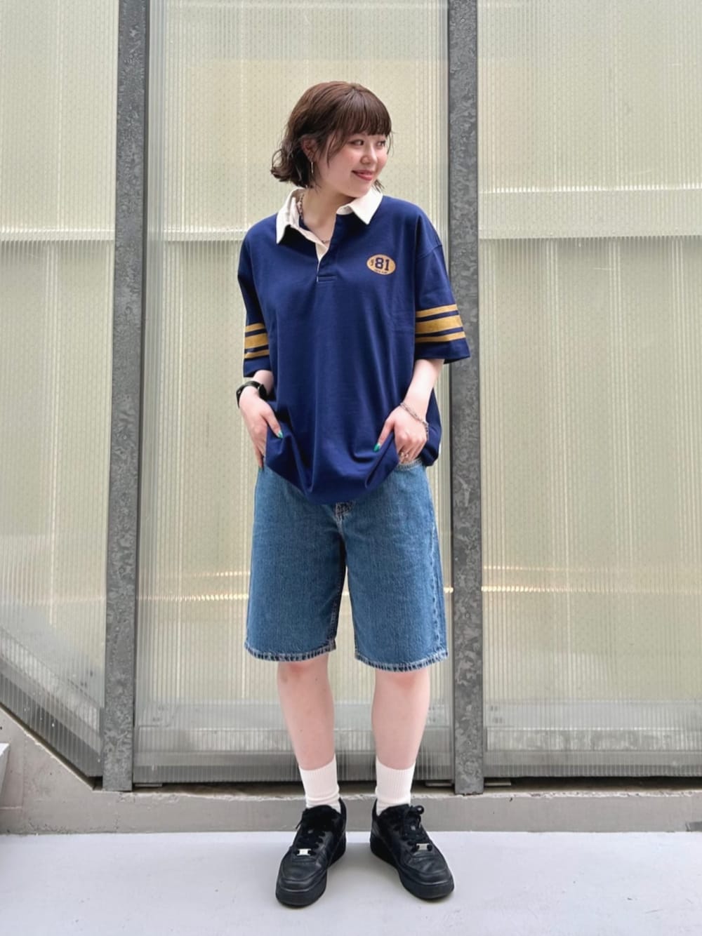 ブルー系のポロシャツ、ブルー系のデニムパンツを着用したレディースの夏コーディネートの1枚目の写真