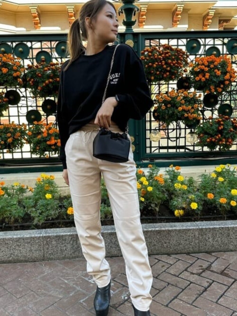 ブラック系のスウェット、ブラック系のハンドバッグ、グレー系のその他パンツを着用したレディースの冬コーディネートの1枚目の写真