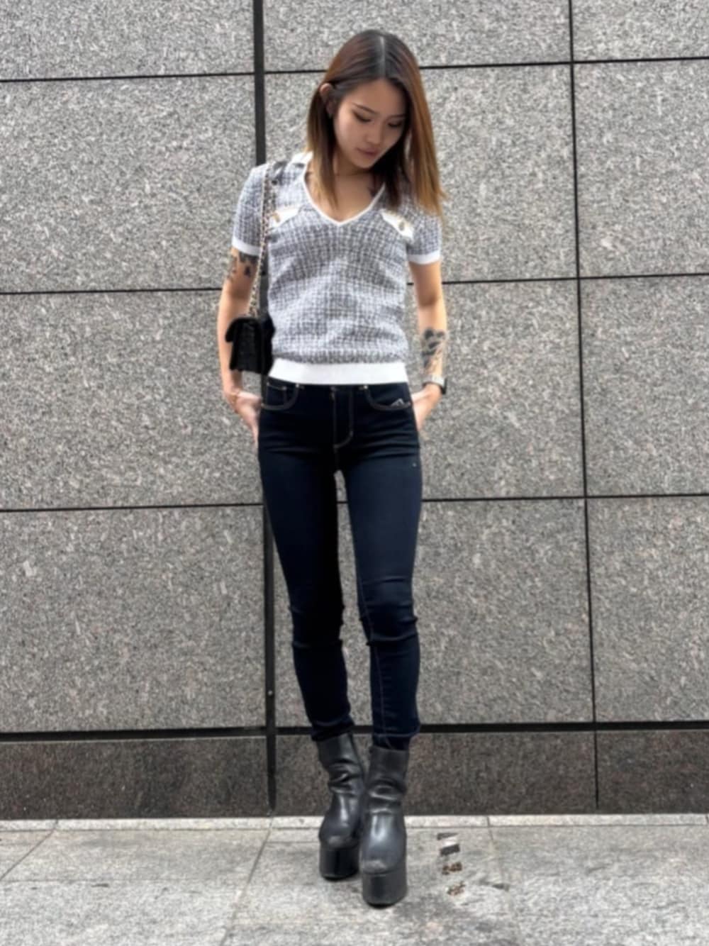 ブルー系のデニムパンツ、ブラック系のショルダーバッグ、ブラック系のニット/セーターを着用したレディースの春コーディネートの1枚目の写真
