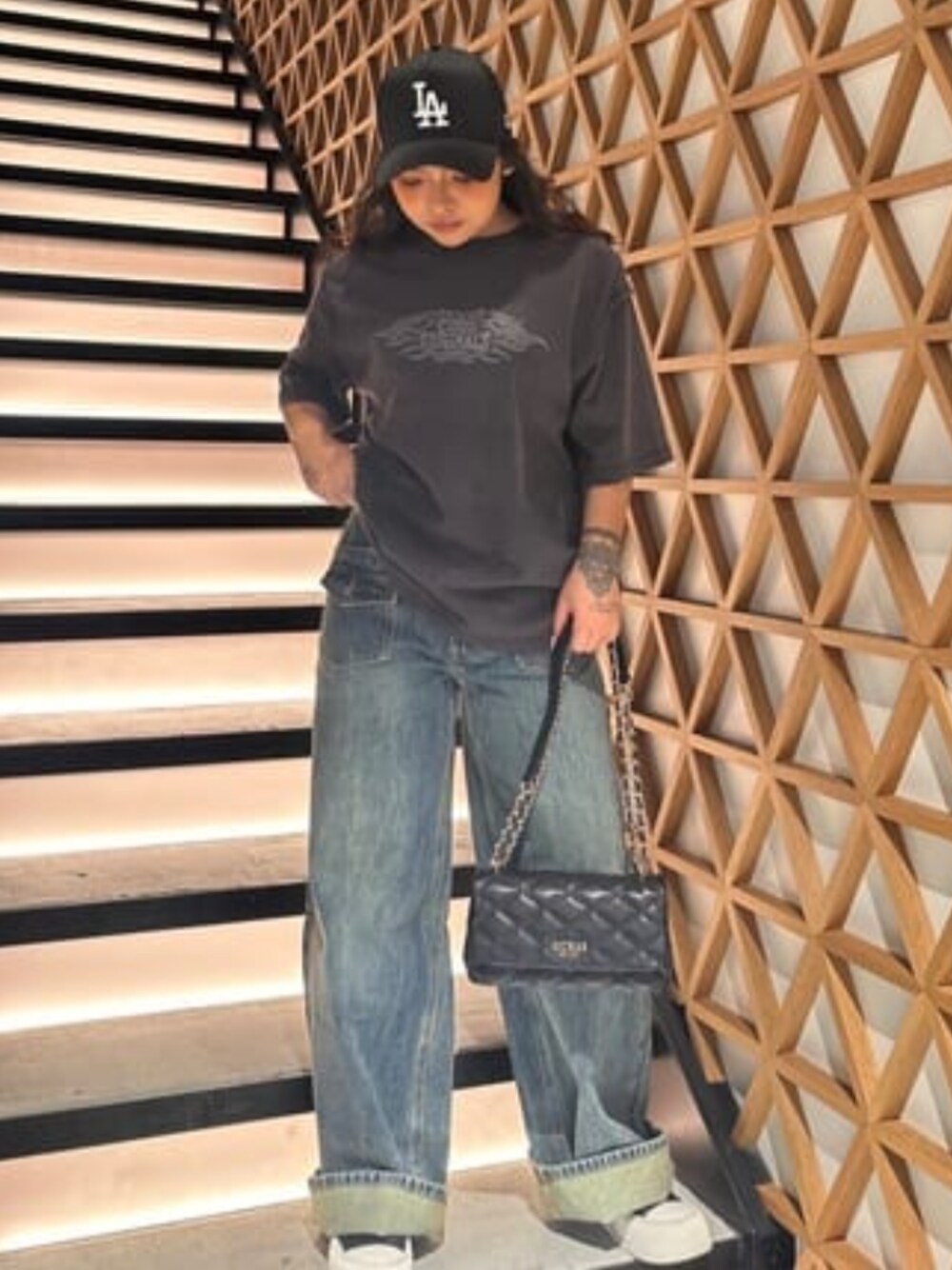 ブラック系のTシャツ/カットソー、ブルー系のデニムパンツ、ブラック系のショルダーバッグを着用したレディースの春コーディネートの1枚目の写真