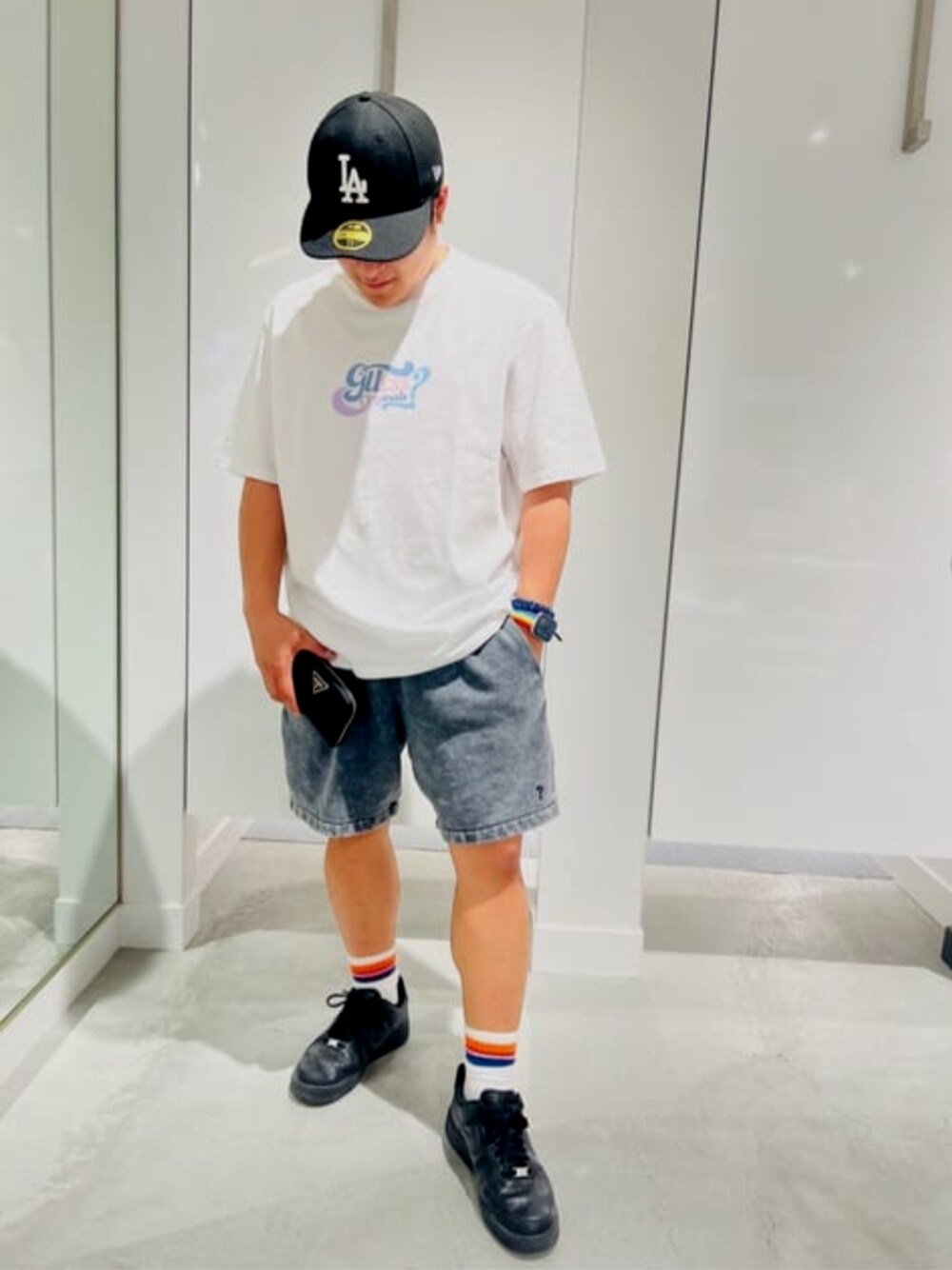 ブラック系のデニムパンツ、ホワイト系のTシャツ/カットソー、ブラック系の財布を着用したメンズの夏コーディネートの1枚目の写真