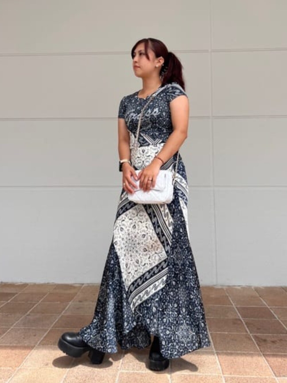 ブルー系のTシャツ/カットソー、ブルー系のスカート、ホワイト系のショルダーバッグを着用したレディースの冬コーディネートの1枚目の写真