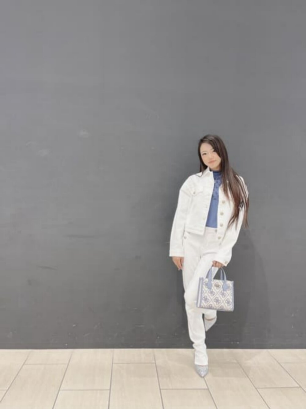 ホワイト系のデニムパンツ、ホワイト系のブルゾン、ブラック系のトートバッグを着用したレディースの秋コーディネートの1枚目の写真