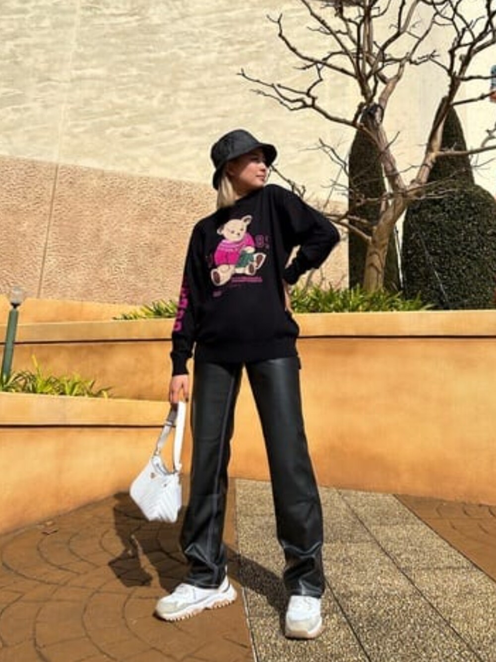 ホワイト系のショルダーバッグ、ブラック系のニット/セーター、ブラック系のその他パンツを着用したレディースの冬コーディネートの1枚目の写真