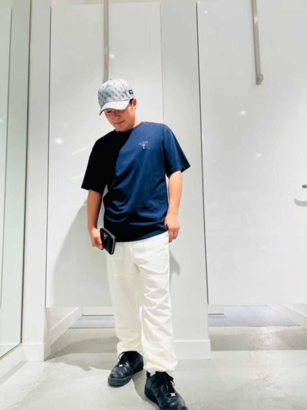 ホワイト系のチノパンツ、ブルー系のTシャツ/カットソー、ブラック系の財布を着用したメンズの春コーディネートの1枚目の写真