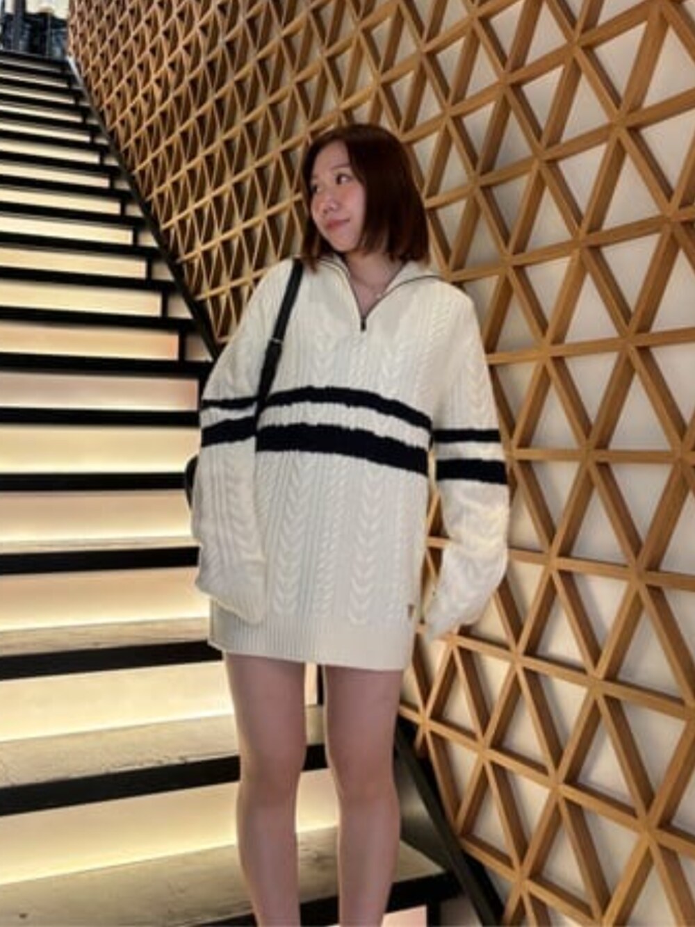 ブラック系のバックパック/リュック、ホワイト系のニット/セーターを着用したレディースの冬コーディネートの1枚目の写真