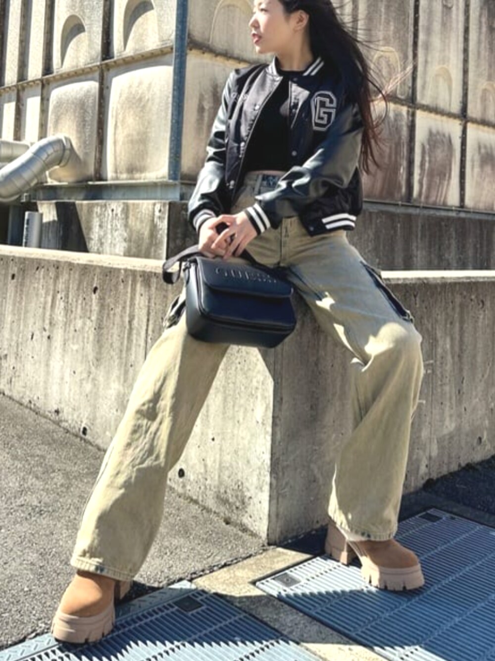 イエロー系のカーゴパンツ、ブラック系のハンドバッグを着用したレディースの春コーディネートの1枚目の写真