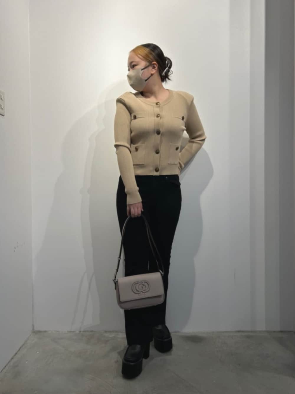 ベージュ系のカーディガン/ボレロ、ブラック系のデニムパンツ、ベージュ系のショルダーバッグを着用したレディースの冬コーディネートの1枚目の写真