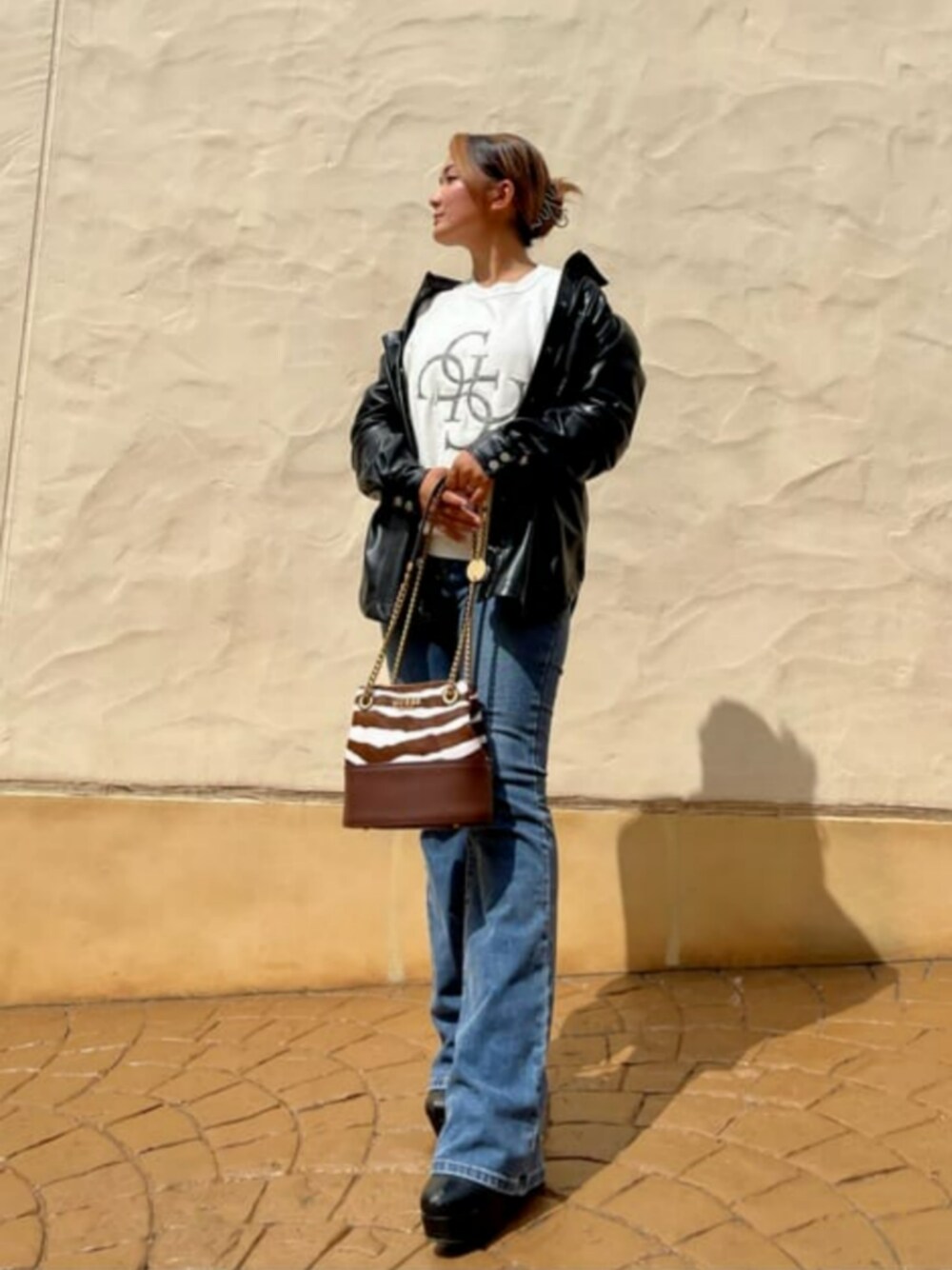 ブルー系のデニムパンツ、ブラック系のシャツ/ブラウス、その他のショルダーバッグを着用したレディースの秋コーディネートの1枚目の写真