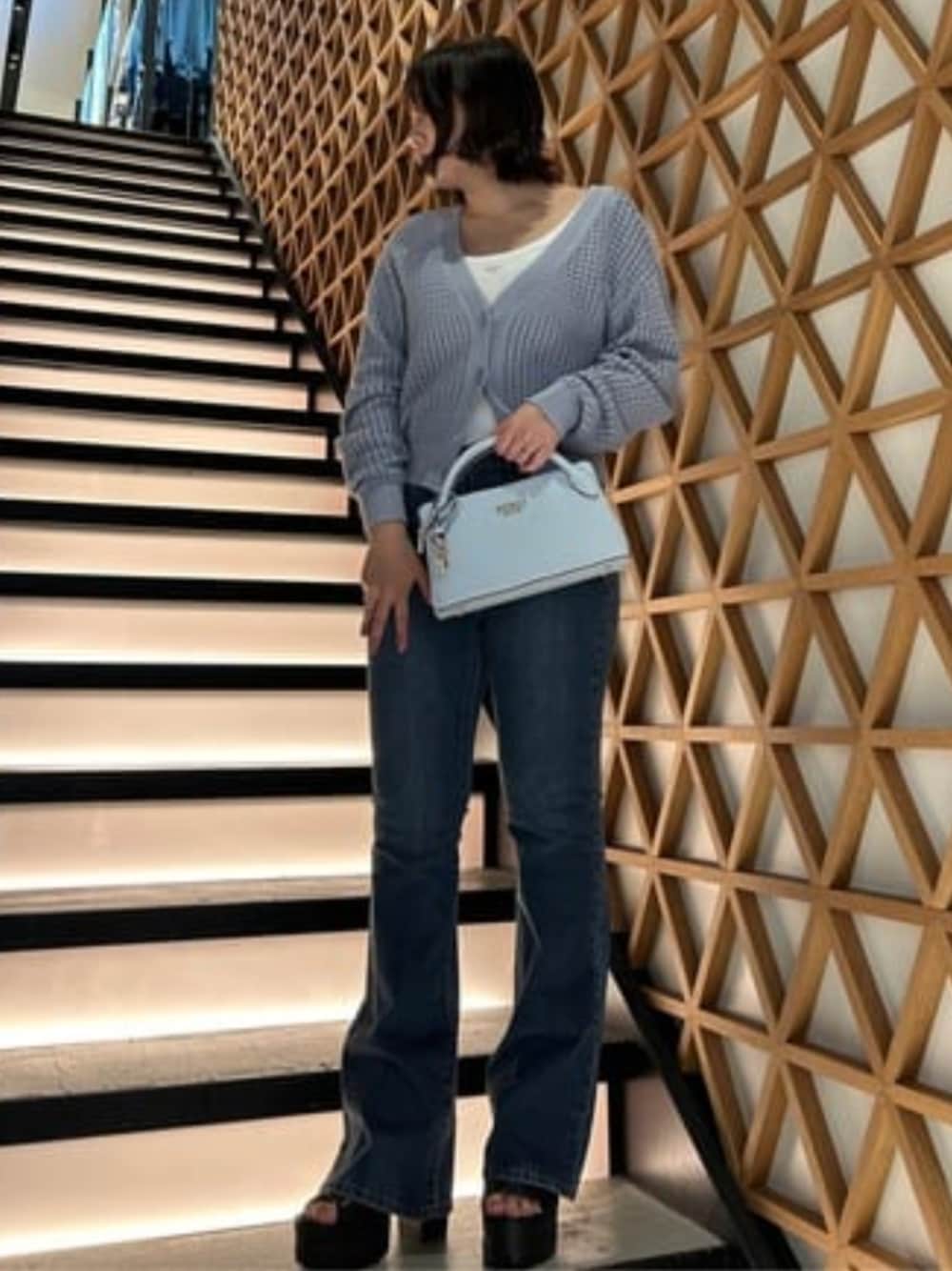 ブルー系のデニムパンツ、ブルー系のカーディガン/ボレロ、ホワイト系のタンクトップを着用したレディースの春コーディネートの1枚目の写真