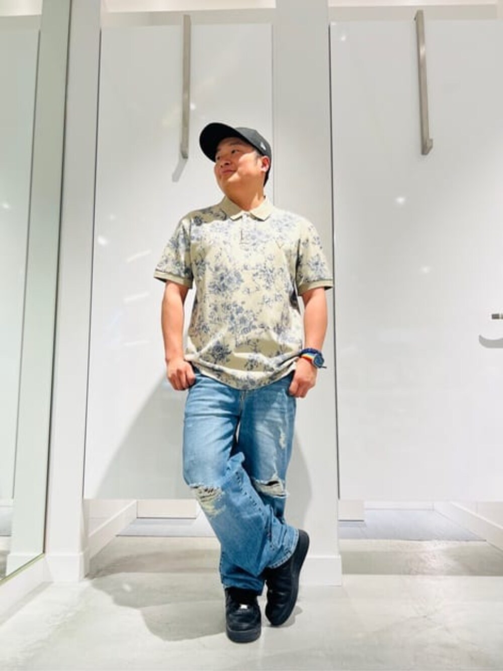 ブルー系のデニムパンツ、ベージュ系のポロシャツを着用したメンズの春コーディネートの1枚目の写真