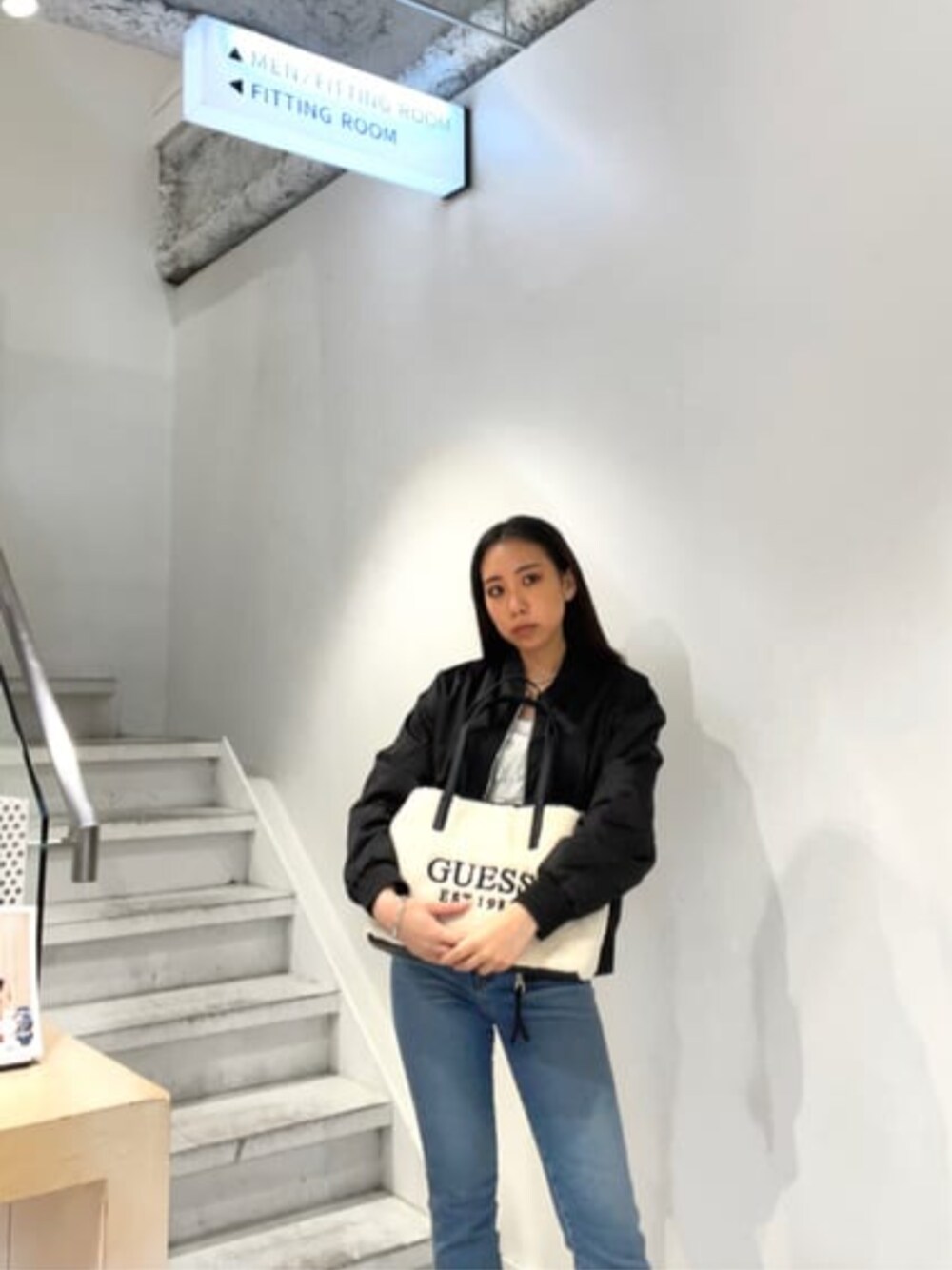 ホワイト系のTシャツ/カットソー、ブルー系のデニムパンツ、ベージュ系のトートバッグを着用したレディースの秋コーディネートの1枚目の写真