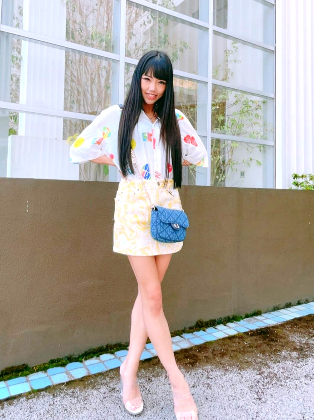 イエロー系のデニムスカート、ホワイト系のシャツ/ブラウス、ブルー系のショルダーバッグを着用したレディースの秋コーディネートの1枚目の写真