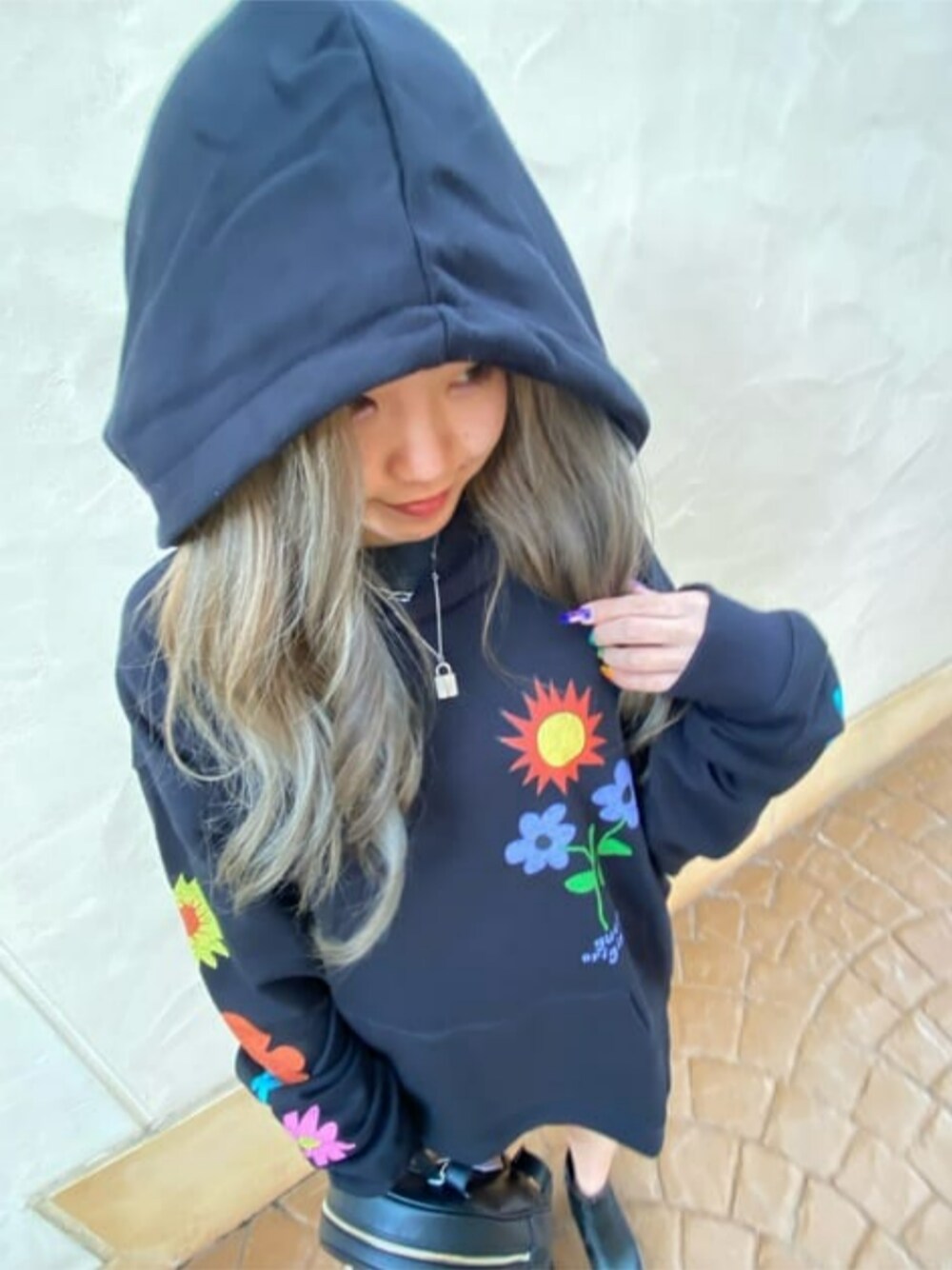 ブラック系のバックパック/リュック、ブルー系のデニムパンツ、ブラック系のパーカーを着用したレディースの春コーディネートの1枚目の写真