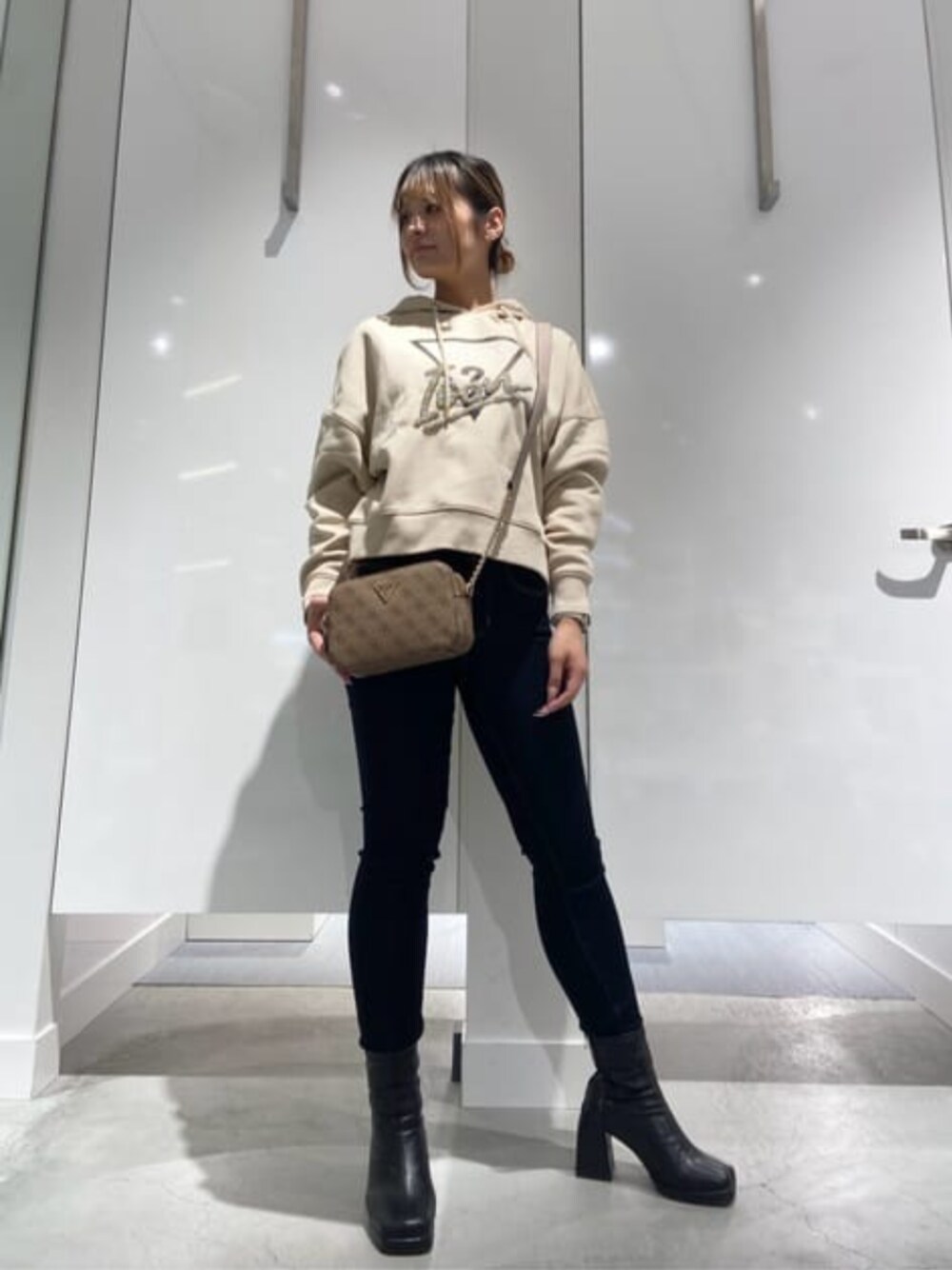 「guess、GUESS、ロゴパーカー、スキニーデニム、カジュアル、カジュアルコーデ」｜「GuessのNOELLE Crossbody Camera（ショルダーバッグ、ベージュ系）」を使った、GUESS JAPANさん（レディース・158cm）の冬コーディネートの1枚目の写真