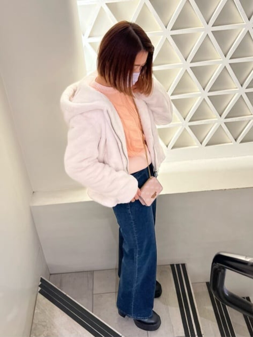 ブルー系のデニムパンツ、ベージュ系のその他アウター、ブラック系のその他アウターを着用したレディースの冬コーディネートの1枚目の写真